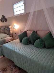 圣罗斯Entre Terre & Mer (Sainte rose)974的一间卧室配有一张带绿色枕头的床