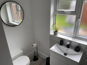 南海灵Modern Ground Floor Garden Apartment With Parking的白色的浴室设有镜子和水槽