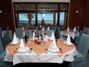 普利拉卡拉古纳酒店的用餐室配有带白餐巾和酒杯的桌子