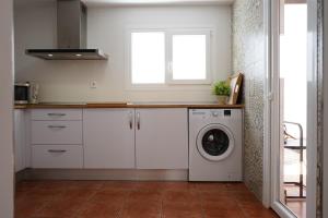 厄尔-汝姆披多Apartamento La Barca的厨房配有洗衣机和窗户。