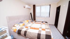 格拉瓦塔斯Penev guest house的一间卧室配有一张带 ⁇ 子毯子的床