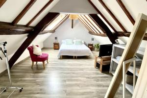 勒克罗图瓦Les Lilas de Mer的阁楼卧室配有床和椅子
