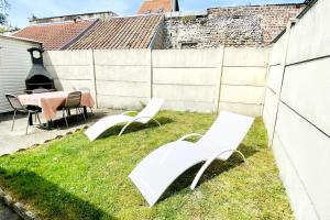 勒克罗图瓦Les Lilas de Mer的两把白色的椅子和一张桌子在院子里