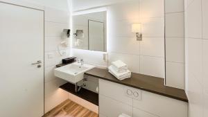 奥斯赛拜-屈隆斯博恩欧罗巴库兰斯伯恩酒店的白色的浴室设有水槽和镜子