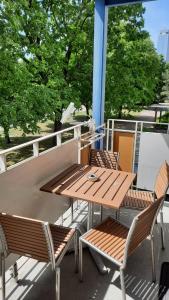 柏林Berlin mednow 1的树木繁茂的阳台配有一张木桌和椅子