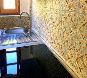 MontpeyrouxMont2roux的一间带水槽和瓷砖墙的厨房