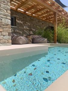 迈洛波塔斯Gianemma Luxury Apartments的后院的游泳池,带有木凉棚