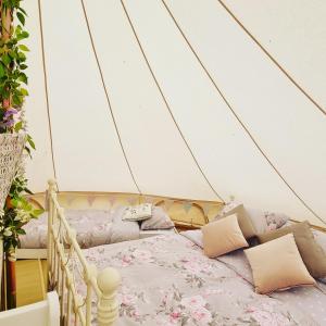 莱肯希思Willow Grove Farm Glamping的帐篷内提供床铺和枕头的客房