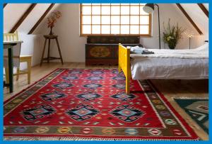 维斯克里Viscri 9的一间铺有红色地毯的客房,位于地板上,配有一张床