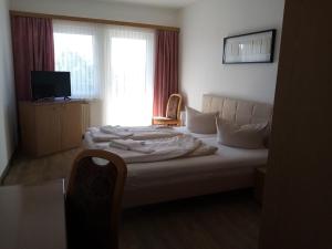 Ostrau祖尔林德酒店的一间卧室配有一张带椅子的床和一扇窗户