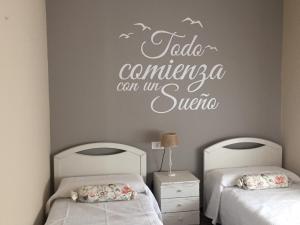 诺哈Vivienda Verano的一间卧室设有两张床和一个可读到talayacancun的标志。