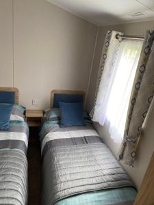 达农Malton 74的两张床位于带窗户的房间内