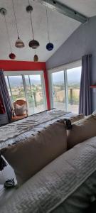 瓜达鲁佩镇Viña Calabria的一间卧室设有一张大床和大窗户