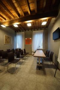 雷焦艾米利亚阿伯阁莫兰迪酒店的一间会议室,配有椅子和木桌