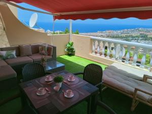 阿德耶Balcon Atlantico Holiday Tenerife的一间带桌椅的客厅和一个阳台