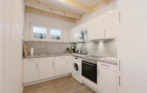 奥尔本尼兹Nice Home In Ostseeresort Olpenitz With Kitchen的厨房配有白色橱柜、洗衣机和烘干机