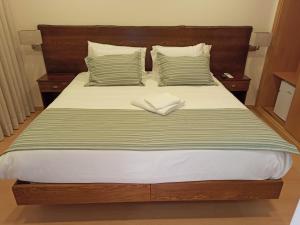 AlpiarçaFontanário House的一张带木制床头板的床和两个枕头