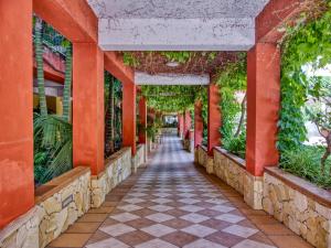 贾迪尼-纳克索斯凯撒皇宫酒店的红柱和植物建筑中的走道