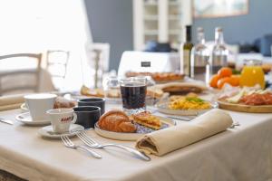 特拉诺瓦-布拉乔利尼Hotel Break House Ristorante的餐桌上摆放着早餐食品和咖啡盘