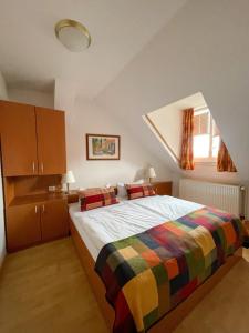 韦尼格罗德艾特维格鲁德公寓式酒店的一间卧室配有一张带彩色毯子的床
