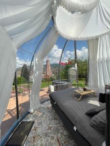萨拉热窝Cupola glamping dome Sarajevo的一间卧室配有一张床,享有庭院的景色