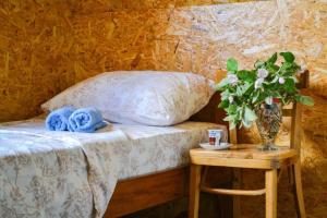 尼克希奇Grandma's Hut的一间卧室配有一张床和一张花瓶桌子