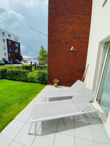 HarelbekeLuxury apartment "Volmolen" with garden, terrace and free parking的砖砌建筑旁的庭院上的一个白色长凳