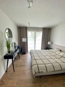 HarelbekeLuxury apartment "Volmolen" with garden, terrace and free parking的一间卧室配有一张床、一张桌子和一面镜子