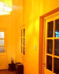 萨尔塔Hostel LQueen 1的黄色的房间,设有门和窗户