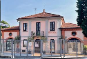 米兰Poste Regie - Milan Guest House的一座粉红色的建筑,前面有一个门