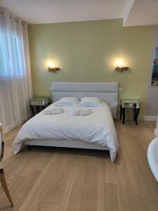比亚里茨Magnifique Villa Biarritz , Jardin et Terrasse的一间卧室配有一张带白色床单的床和两张桌子