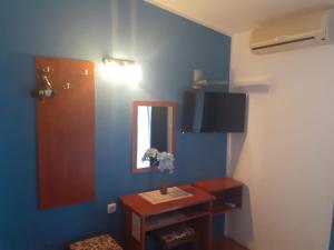 马卡尔斯卡Guest House Damir的一间设有一张桌子和镜子的蓝色墙壁客房