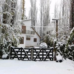 马拉圭Los Abedules Bungalow的雪中带围栏的房子