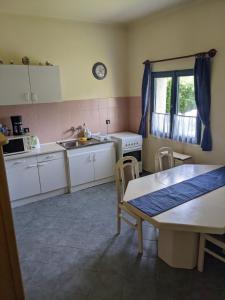 锡尔沃斯瓦里德Tulipan Haz的厨房配有白色橱柜、桌子和水槽。
