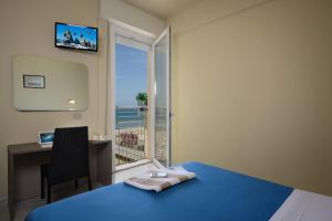 加比切马莱艾克塞西尔酒店的一间卧室配有一张床、一张书桌和一个窗户。