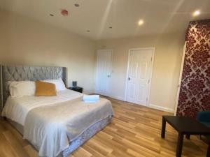 利兹Roundhay Apartments的一间卧室设有一张大床,铺有木地板
