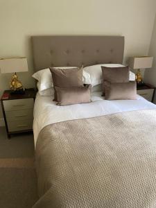 奥赫特拉德Gleneagles Holiday Home的一间卧室配有一张大床、枕头和两盏灯。