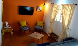 圣希尔GREEN HOUSE CASA O APARTAMENTO CAMPESTRE的客厅配有两把椅子和电视