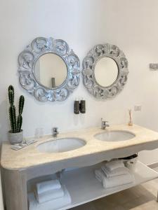 奥尔比亚In centro unique rooms的浴室设有两个水槽和墙上的镜子