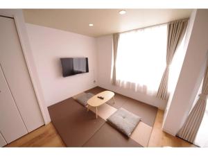 金泽HOTEL APT SESELA - Vacation STAY 12877的一个带桌子和电视的小客厅