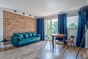 苏普拉希尔Apartament Wschodni的客厅配有蓝色的沙发和桌子