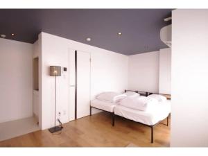 金泽HOTEL APT SESELA - Vacation STAY 12884的卧室拥有白色的墙壁,配有一张带白色枕头的床。