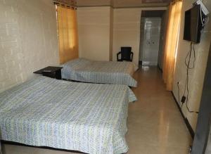 圣罗莎德卡瓦尔Hostal San Ramon的配有电视的酒店客房内的两张床