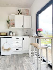 SwanlinbarSwan Cabin的厨房配有白色橱柜和桌子