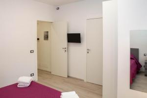 拉古萨码头Endless Summer Apartment的一间拥有白色墙壁和紫色地毯的房间