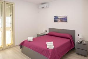 拉古萨码头Endless Summer Apartment的一间卧室配有一张带粉色毯子的大床