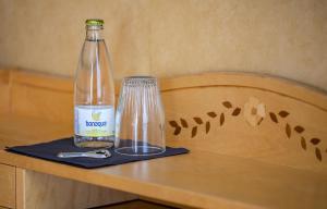 瑟德港Christos Hotel的玻璃旁边的桌子上的一瓶