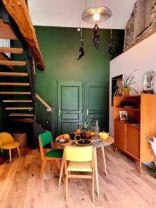Saint-Auban-dʼOzeLe Petit Bégou的一间拥有绿色墙壁和桌椅的用餐室