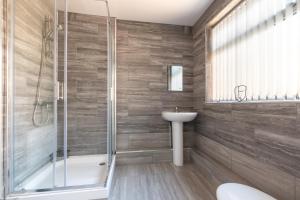 考文垂Tanzanite - 5 Bedroom House / Sleeps 10的带淋浴、卫生间和盥洗盆的浴室