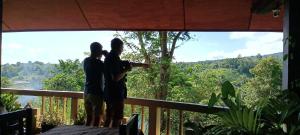 BitungTangkoko Sanctuary Villa的两人站在一个眺望着森林的阳台
